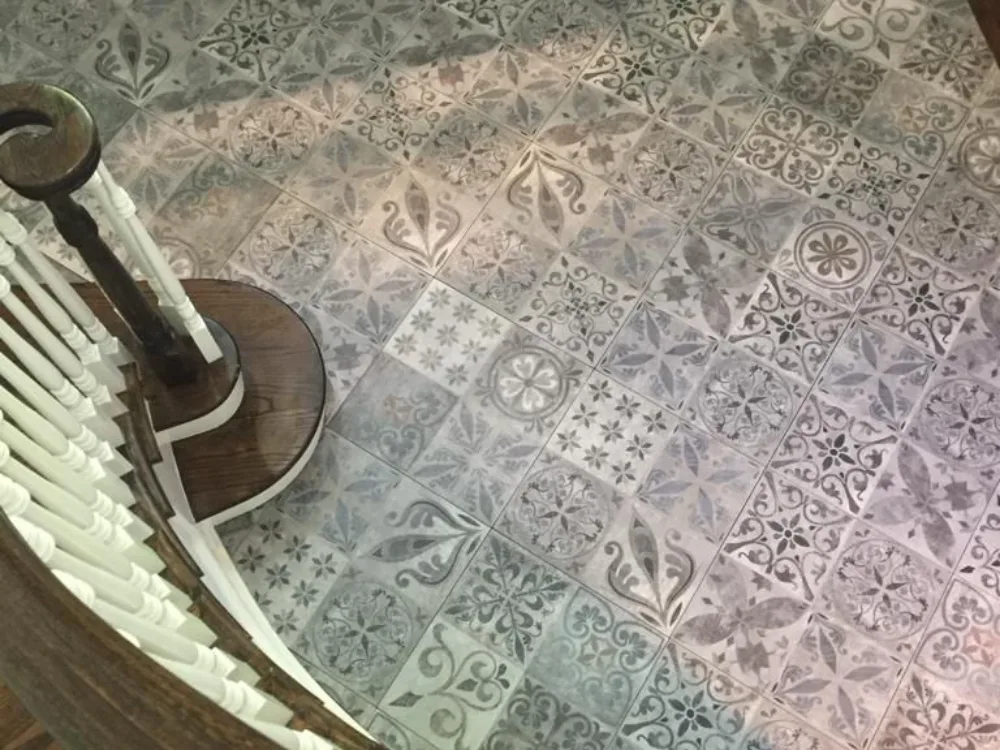 Decorative tile floor installation completed in a residential entryway with patterned tiles and precise alignment