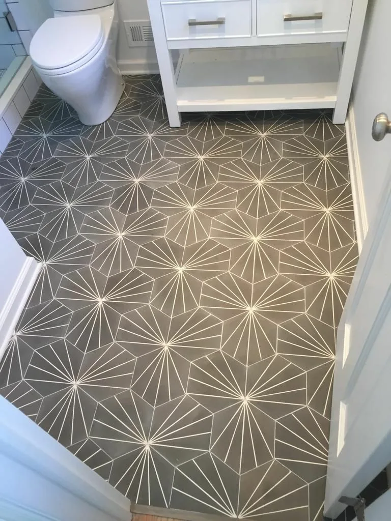 Lavatory tile installation showcasing geometric patterned floor tiles with precise alignment and clean grout lines