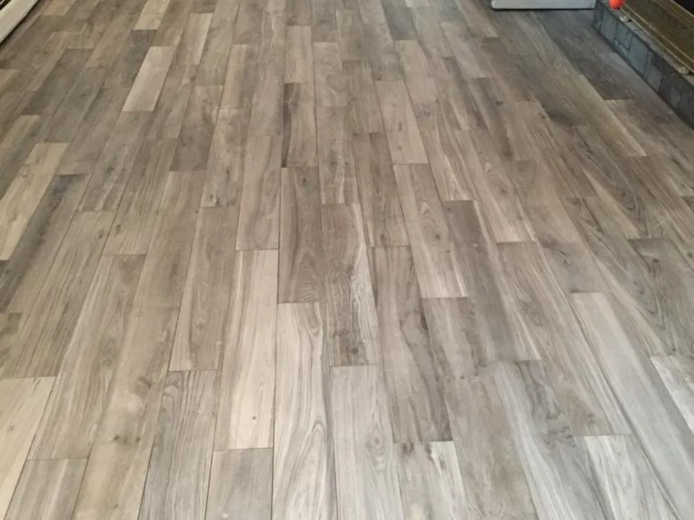 Angle view of a completed modern residential flooring installation with a gray wood-look finish.