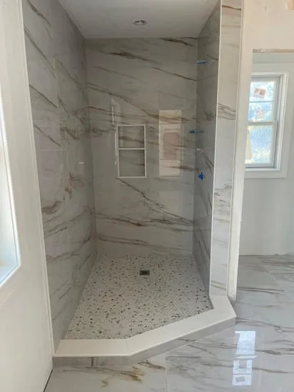 A wide shot of the finished custom shower stall, showcasing the comprehensive marble shower tile installation.